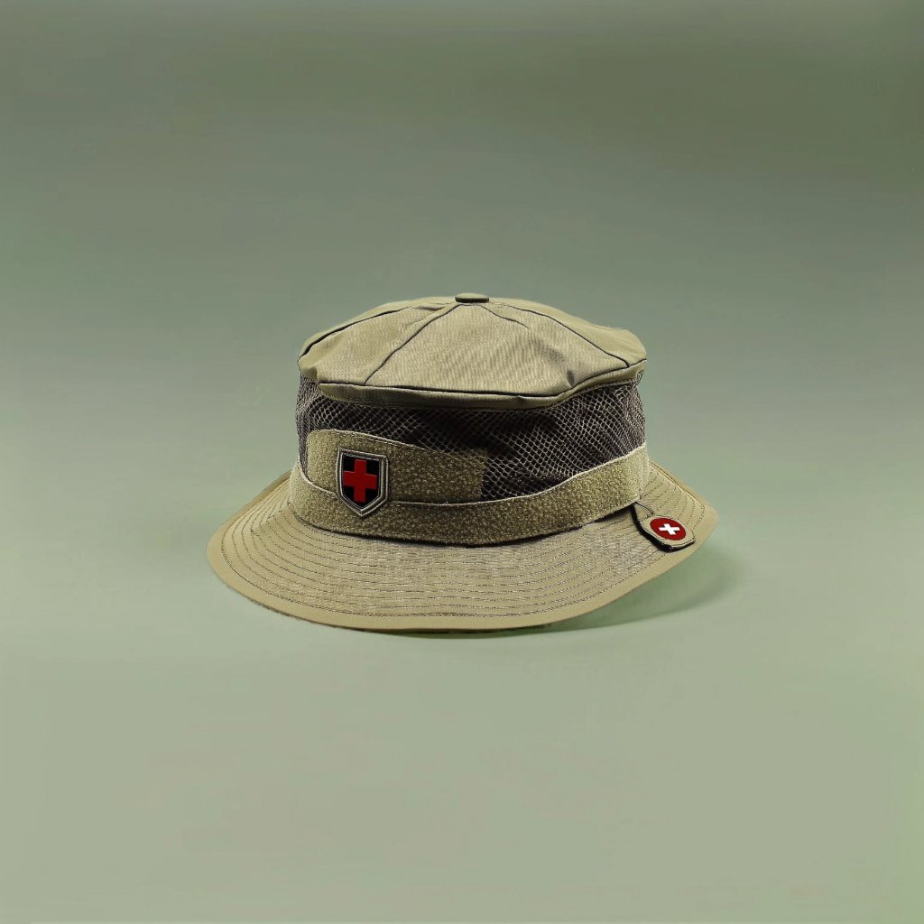 An e-commerce product image of a dark green bucket hat lying on the grass covered with brown fallen leaves. 